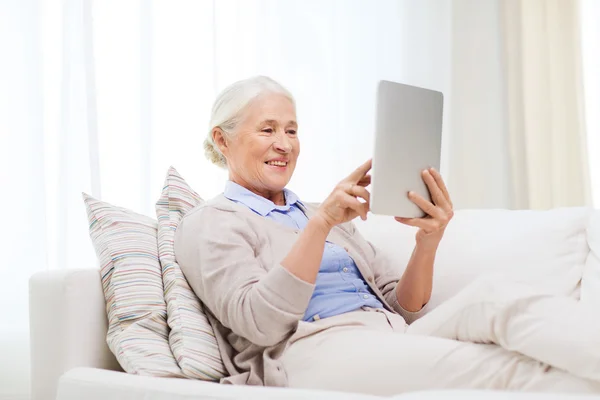 Счастливая пожилая женщина с планшетным компьютером — стоковое фото