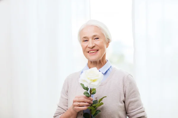 Mulher sênior feliz com flor de rosa — Fotografia de Stock