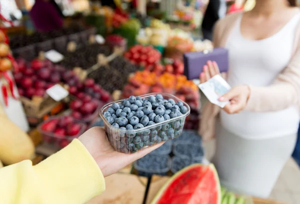 Schwangere mit Geld kauft Beeren auf dem Markt — Stockfoto