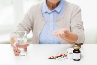 close up of senior woman with water and pills clipart