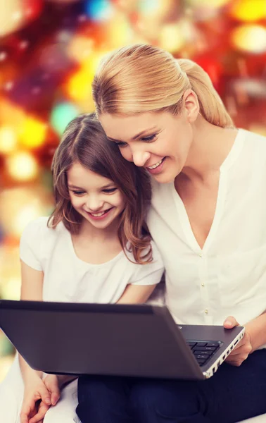 Lächelnde Mutter und kleines Mädchen mit Laptop — Stockfoto