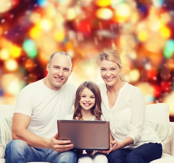 Familia sonriente con portátil — Foto de Stock