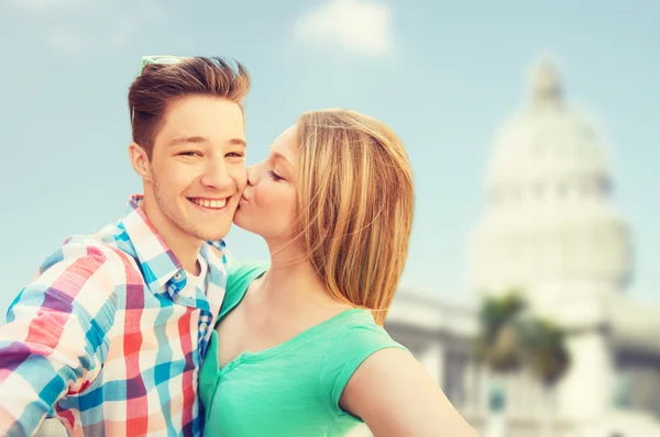 Couple kissing and taking selfie over white house — Stock Photo, Image