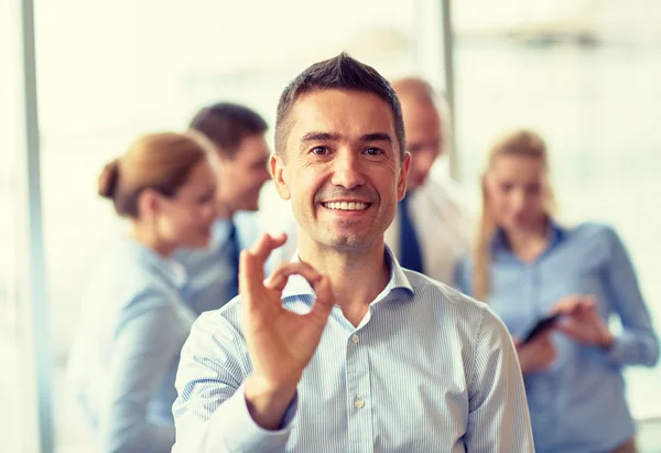 Grupo de empresarios sonrientes reunidos en el cargo — Foto de Stock