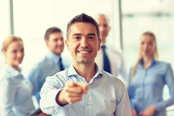 Grupo de empresarios sonrientes reunidos en el cargo — Foto de Stock