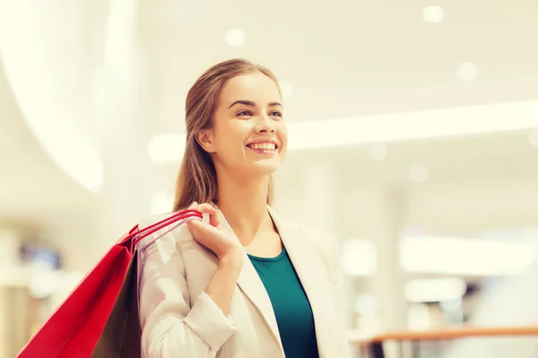 Mujer joven feliz con bolsas de compras en el centro comercial —  Fotos de Stock