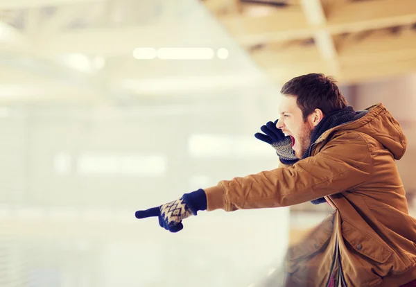 Young man supporting hockey game on skating rink — Stock Photo, Image