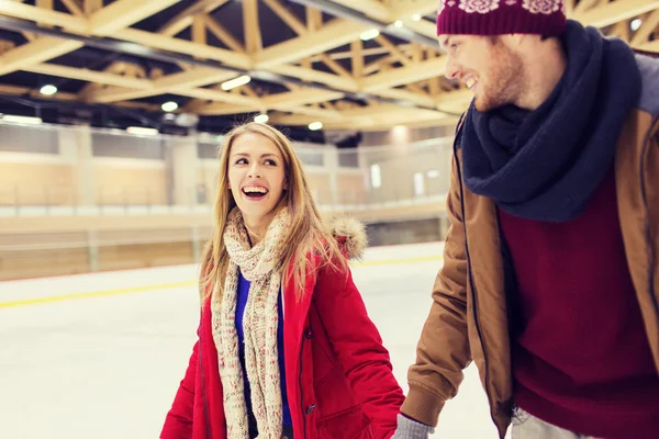 Feliz pareja cogida de la mano en pista de patinaje — Foto de Stock