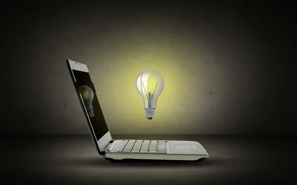 Открытый ноутбук с лампочкой — стоковое фото