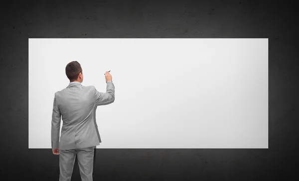 Businessman writing or drawing on white board — Stock Photo, Image