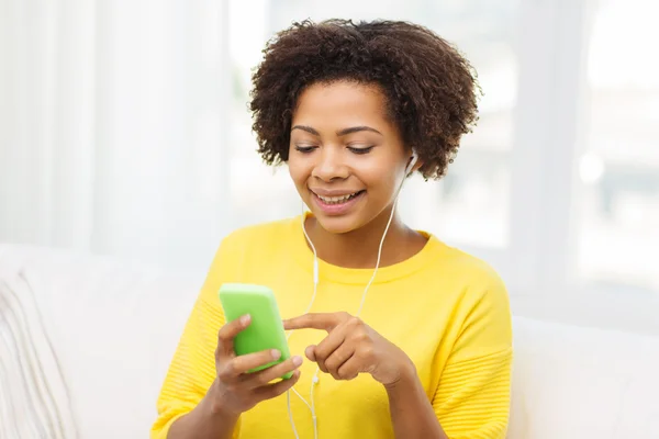 Mulher africana feliz com smartphone e fones de ouvido — Fotografia de Stock