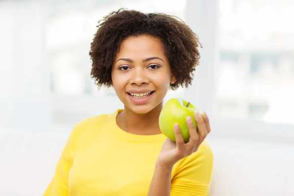 Mujer afroamericana feliz con manzana verde —  Fotos de Stock