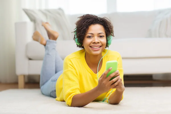 Happy african woman with smartphone and headphones — Stock Photo, Image