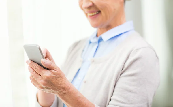 Äldre kvinna med smartphone-textning — Stockfoto