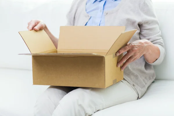 Primer plano de la mujer mayor con caja de paquetes en casa —  Fotos de Stock