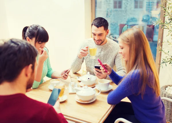 Group of friends with smartphones meeting at cafe Royalty Free Stock Photos