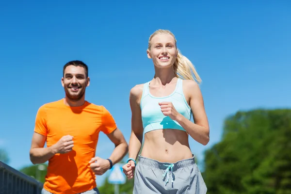 Smiling couple running outdoors Royalty Free Stock Images