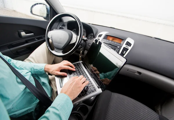 Κοντινό πλάνο νεαρός άνδρας με φορητό υπολογιστή, οδήγηση αυτοκινήτου — Φωτογραφία Αρχείου