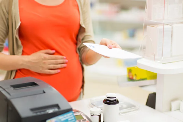 Mulher grávida comprando medicação na farmácia — Fotografia de Stock