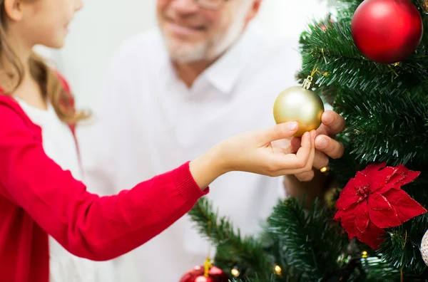 Close up of happy family decorating christmas tree — Stock Photo, Image