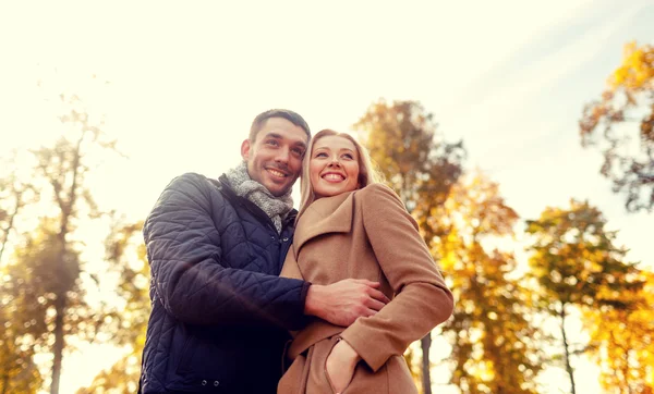 Coppia sorridente che si abbraccia nel parco autunnale — Foto Stock