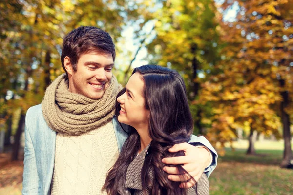 Casal sorridente abraçando no parque de outono — Fotografia de Stock