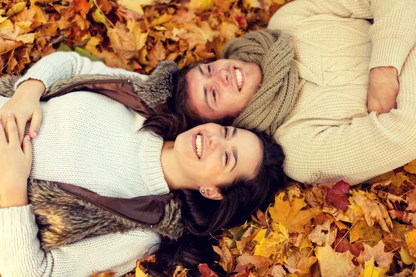 Sorrindo casal deitado no parque de outono — Fotografia de Stock