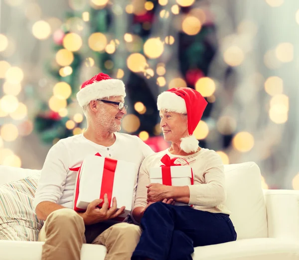 Glückliches Seniorenpaar in Weihnachtsmannmützen — Stockfoto
