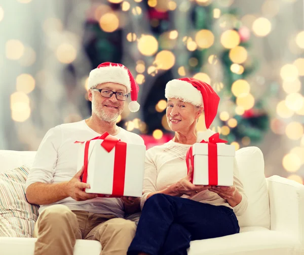 Happy senior couple in santa hats — Stock Photo, Image