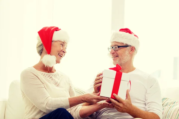 Glückliches Seniorenpaar in Weihnachtsmannmützen — Stockfoto