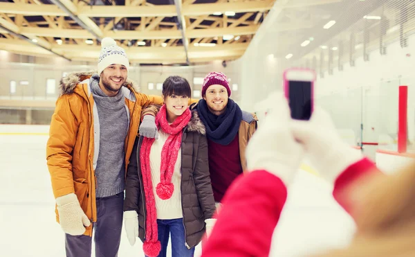 Amis heureux prenant des photos sur la patinoire — Photo