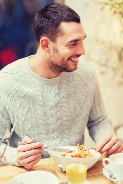 Happy young man having dinner at restaurant — Stock Photo, Image