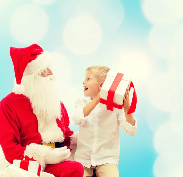 Lächelnder kleiner Junge mit Weihnachtsmann und Geschenken — Stockfoto