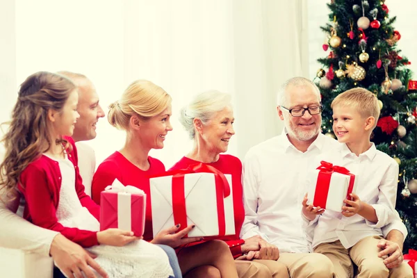 Famiglia sorridente con regali a casa — Foto Stock