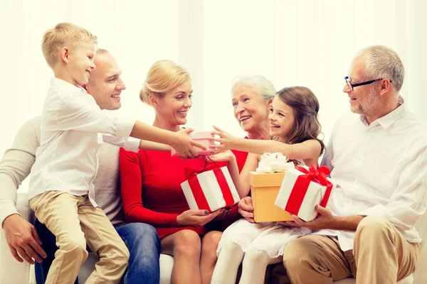 Famiglia sorridente con regali a casa — Foto Stock