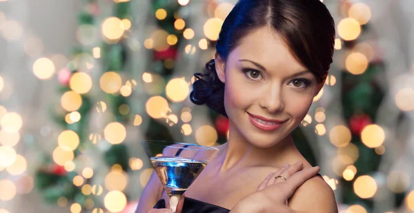 Frau mit Cocktail über Weihnachtsbeleuchtung — Stockfoto