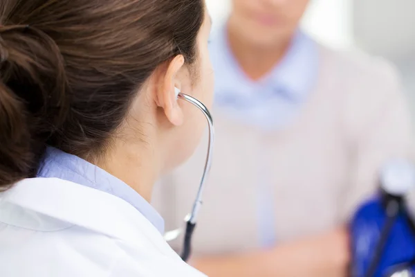 Doctor con tonómetro y mujer mayor en el hospital — Foto de Stock