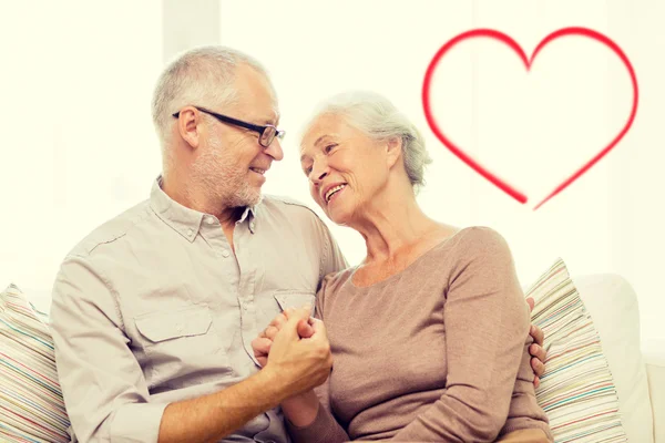 Happy senior couple hugging on sofa at home — Stock Photo, Image