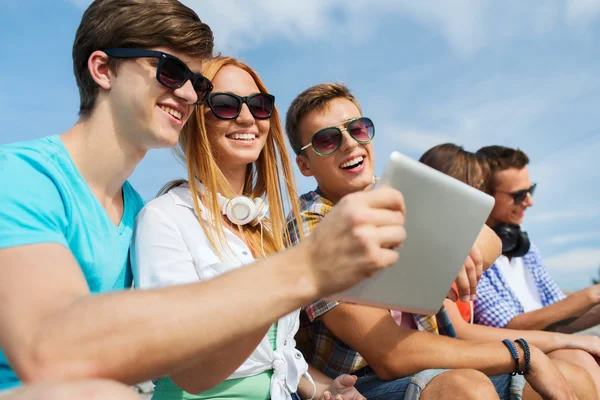 Grupo de amigos sonrientes con tableta PC al aire libre — Foto de Stock