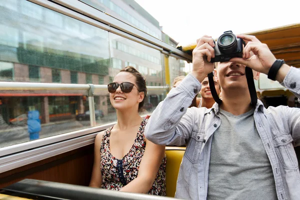 Coppia sorridente con macchina fotografica che viaggia in autobus turistico — Foto Stock
