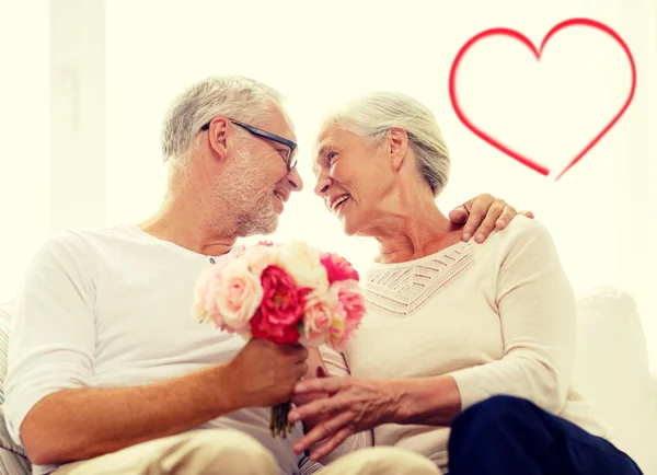 Happy senior couple with bunch of flowers — Stock Photo, Image