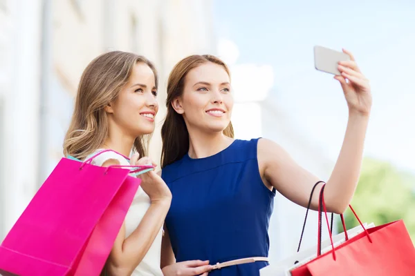 Vrolijke vrouwen met boodschappentassen en smartphone Rechtenvrije Stockafbeeldingen