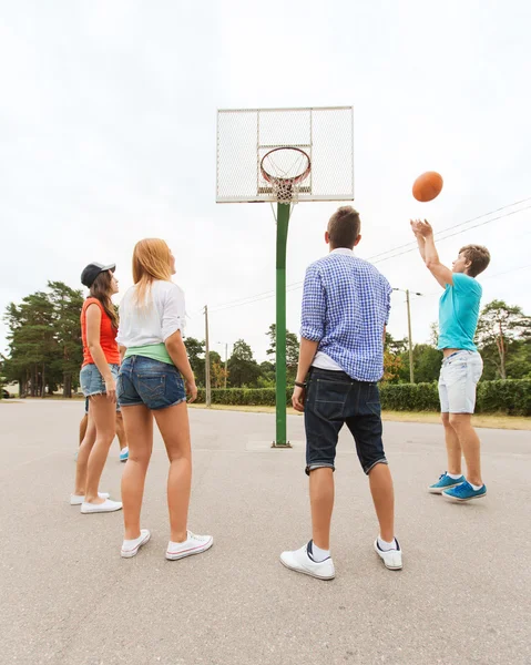 Skupina happy teenagerů hrát basketbal — Stock fotografie