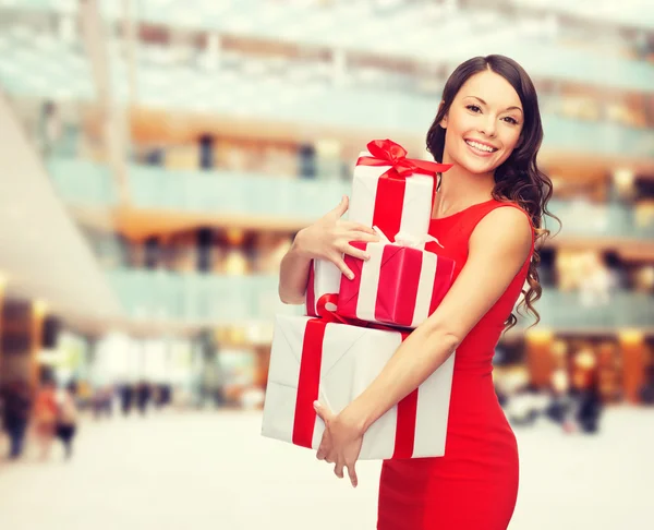 Mujer en vestido rojo con cajas de regalo —  Fotos de Stock