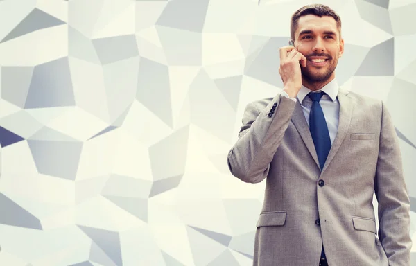 Smiling businessman with smartphone outdoors — Stock Photo, Image