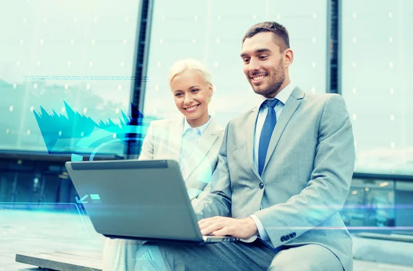 Sonrientes empresarios con portátil al aire libre —  Fotos de Stock