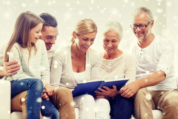 Famille heureuse avec livre ou album photo à la maison — Photo