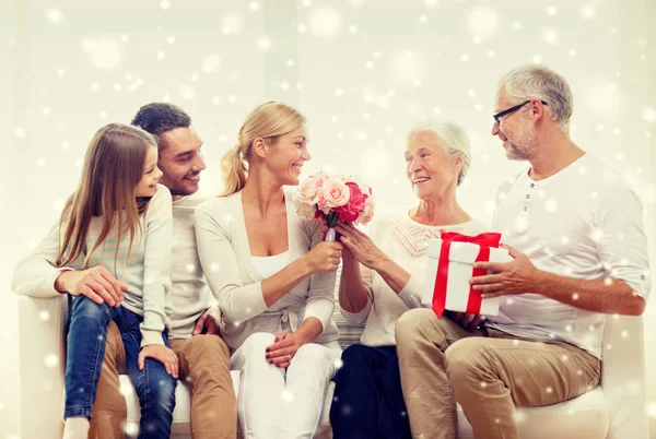 Familia feliz con racimo y caja de regalo en casa — Foto de Stock