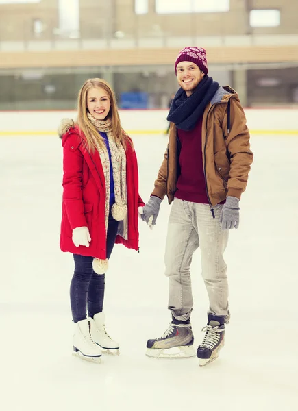 Feliz pareja cogida de la mano en pista de patinaje —  Fotos de Stock