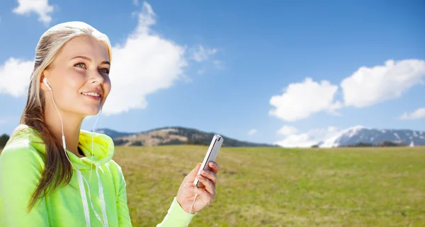 Mujer con smartphone y auriculares haciendo deporte — Foto de Stock